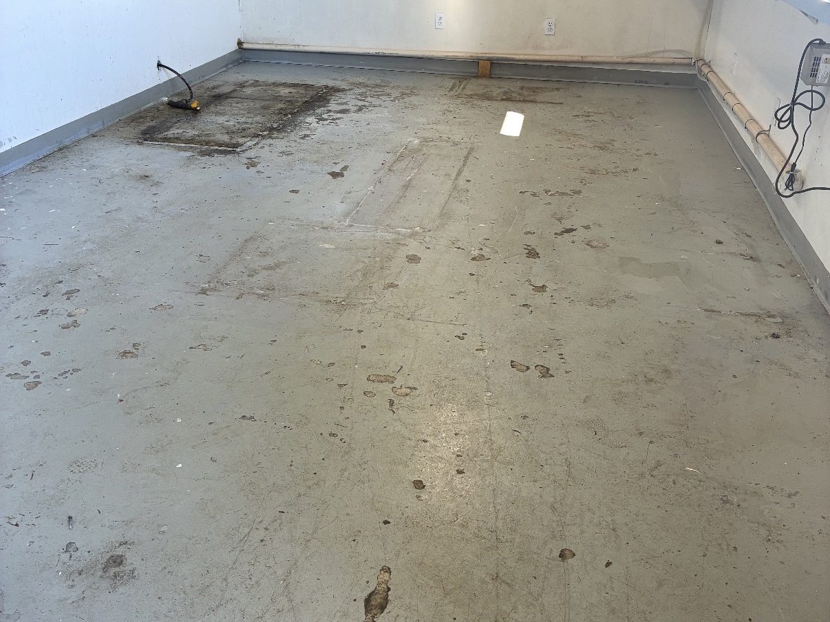 Commercial space before, bare stained concrete